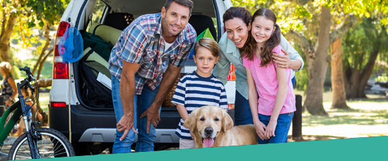 family in front of car with dog