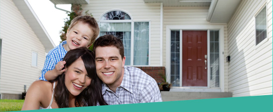 smiling family in front of house