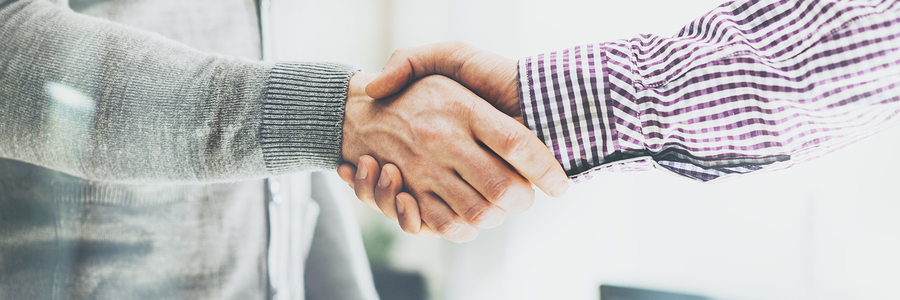 two men shaking hands after coming to a business agreement