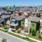 Aerial view of colorful modern homes in a Texas neighborhood with solar panels and well-kept lawns.